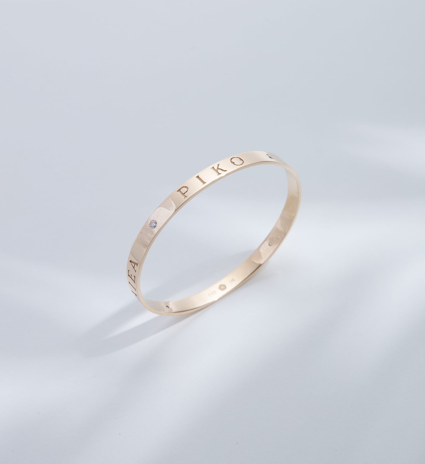 Hie Aloha Nui bangle bracelet in gold, engraved with the name Piko and including diamond accents