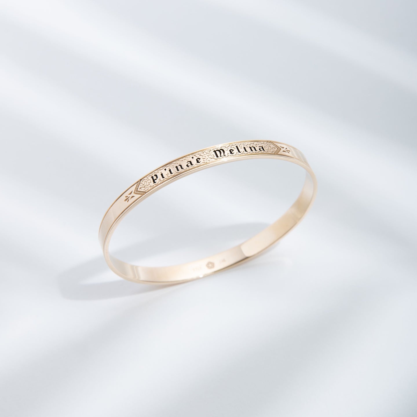 Hie Li’ili’i gold bangle bracelet with engraving, standing upright