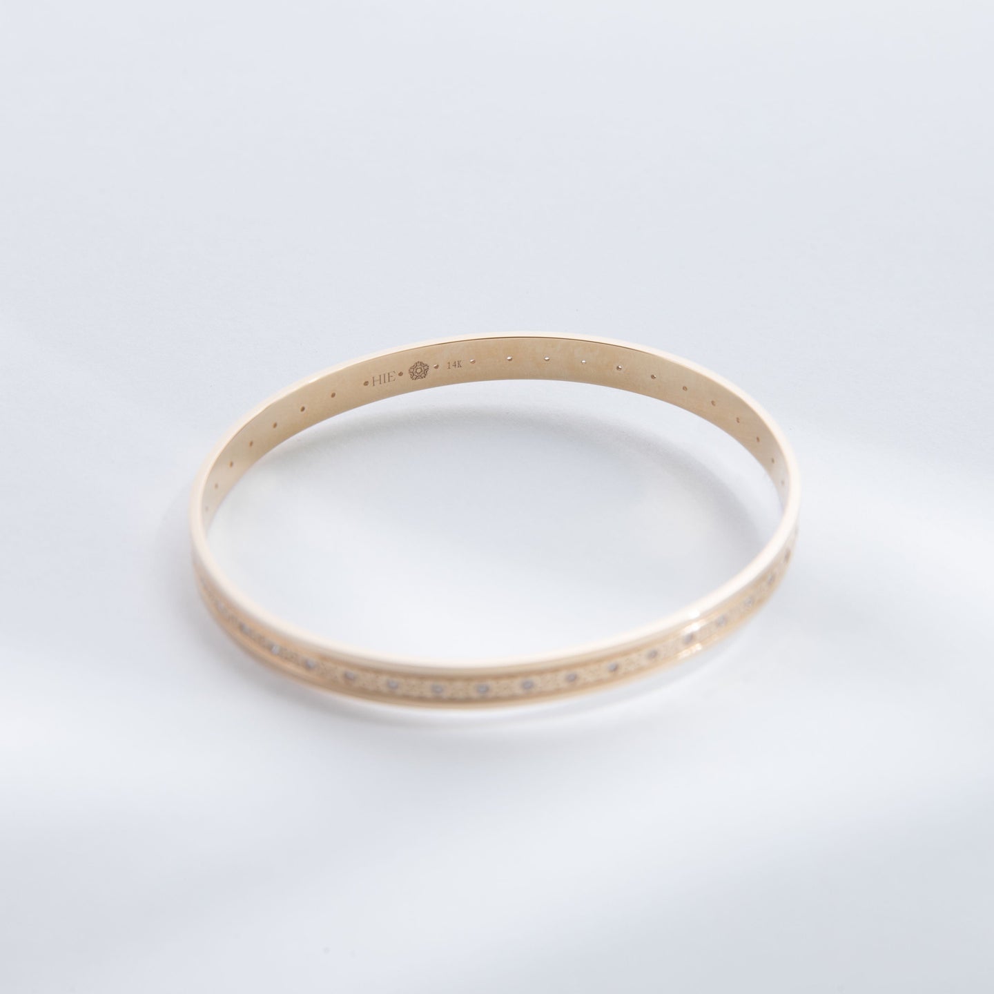 Hie Tutu Leslie gold bangle bracelet with engraved pattern and diamonds, focus on interior engraving