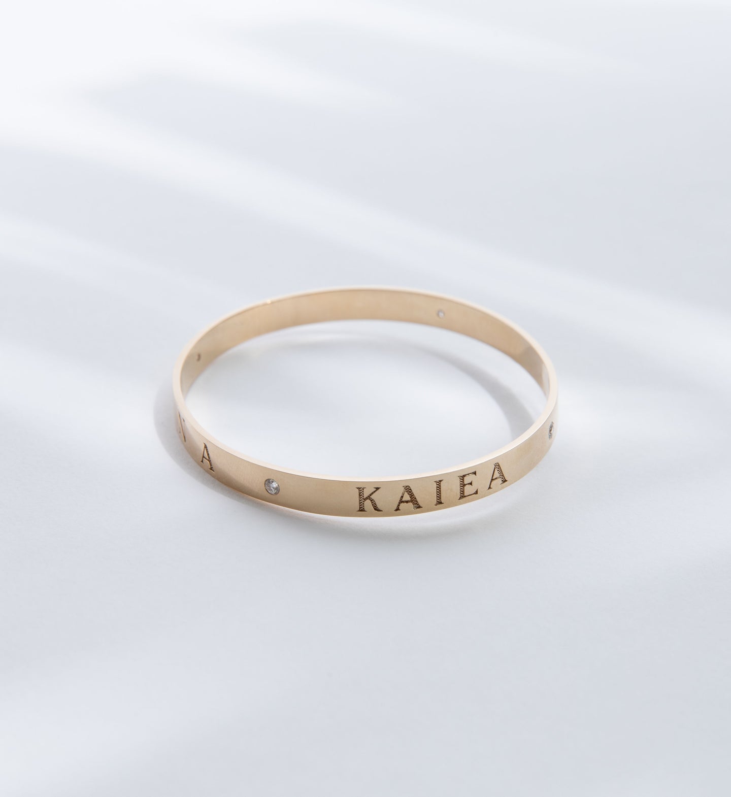 Hie Aloha Nui bangle bracelet in gold, engraved with the name Kaiea and including diamond accents
